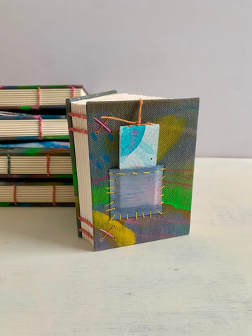 a collection of handmade art journals with colourful covers