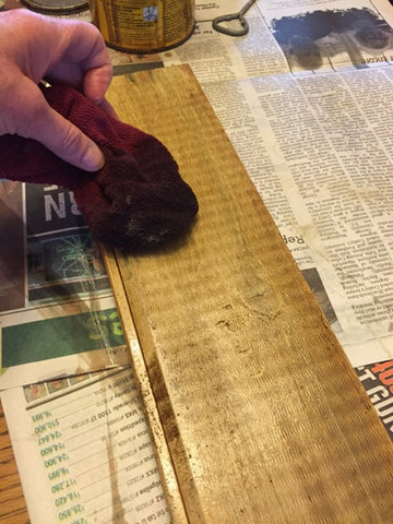 adding stain to wood board