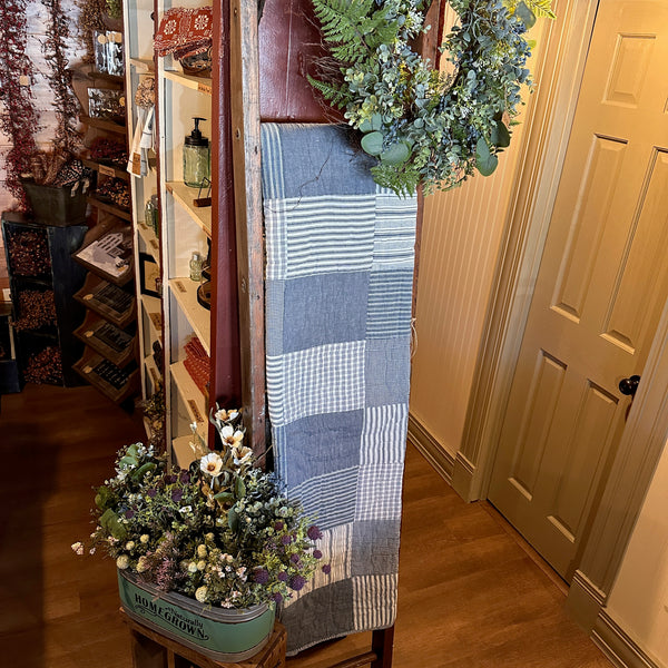 single quilt displayed on a ladder