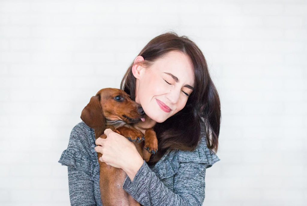 A woman hugging a brown dog