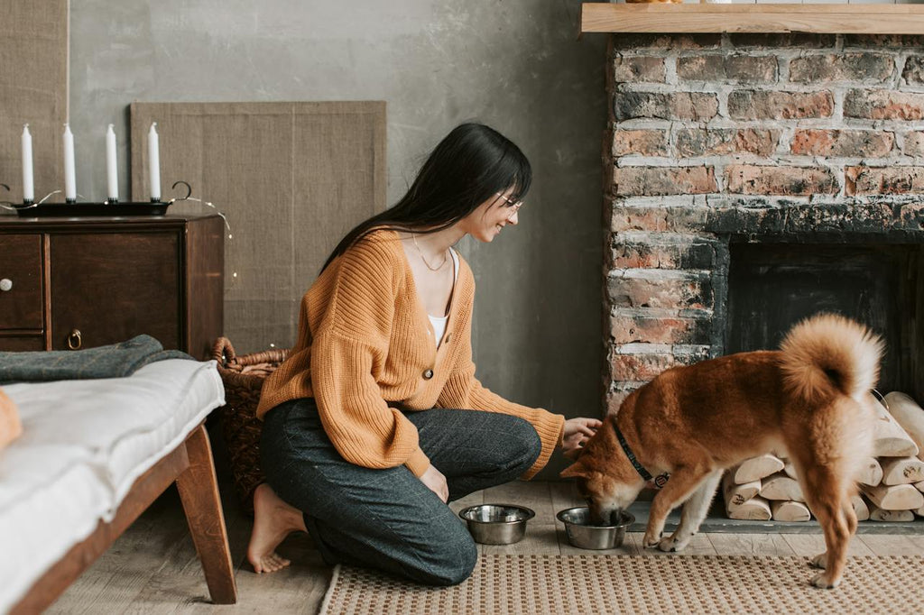 A woman feeding her dog kibble