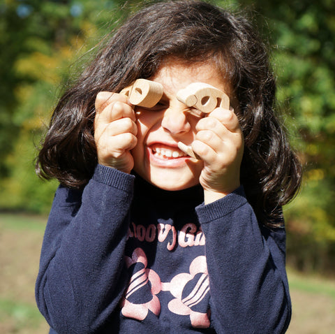 A girl covers her eyes with the letters of My Arabic Alphabet