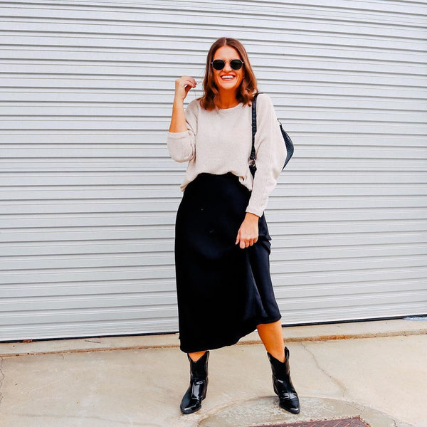 Jasmine styling our deborah satin midi skirt with black boots and a cream knit 