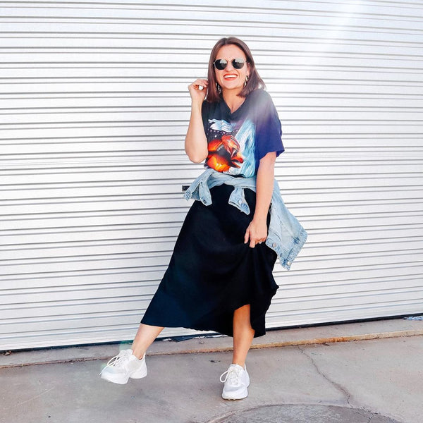 Jasmine from Pretty Chuffed styling your Deborah black satin midi skirt with a tee, denim jacket and white sneakers. 