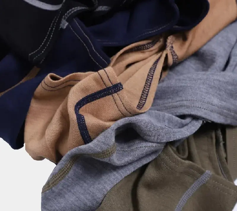 Nahaufnahme einer Sammlung von Merinowoll-Balaclavas in Marineblau, Beige, Grau und Olivgrün, die ihre robusten Nähte und den weichen Stoff hervorhebt, ideal für den Kälteschutz mit Komfort.