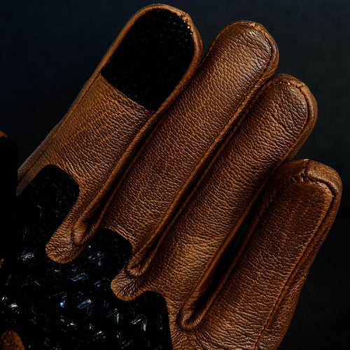 close up of brown leather motorcycle gloves with touchscreen panel material on index finger