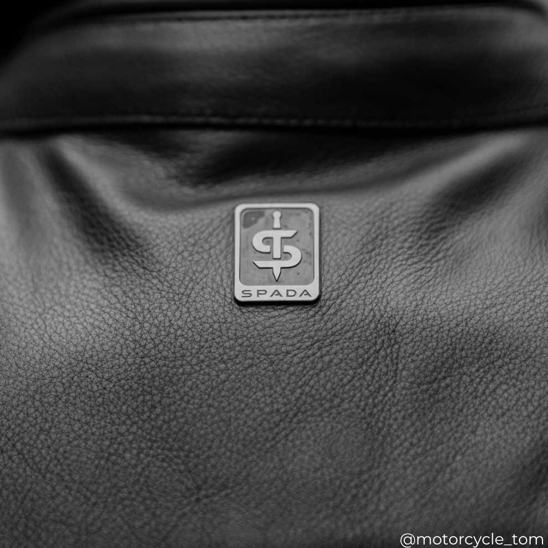 close up of back of black motorcycle jacket for men with spada logo on