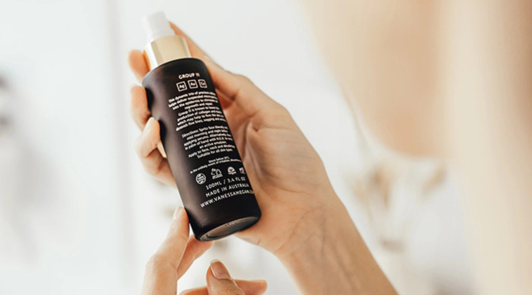 Woman reading the INCI label of Vanessa Megan Group 11 Active Mist, ensuring transparency in skincare ingredients for informed natural beauty choices.