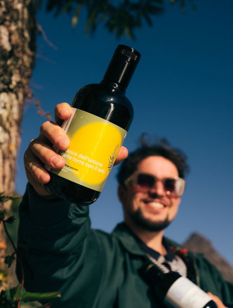 happy man holding a bottle of prestigious extra vergin olive oil