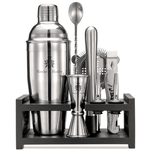 Stainless steel bartender kit from a front view, inside a black bamboo stand, against a white background