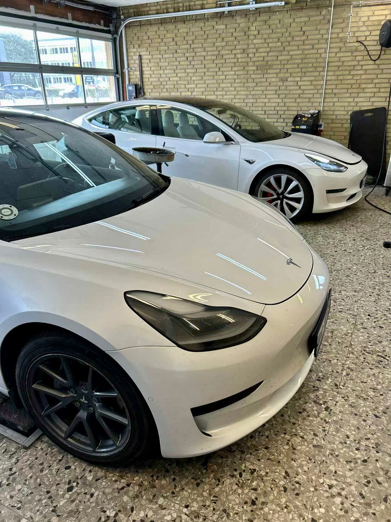 To styk Tesla Model 3 på værksted hos Ekstrand Garage