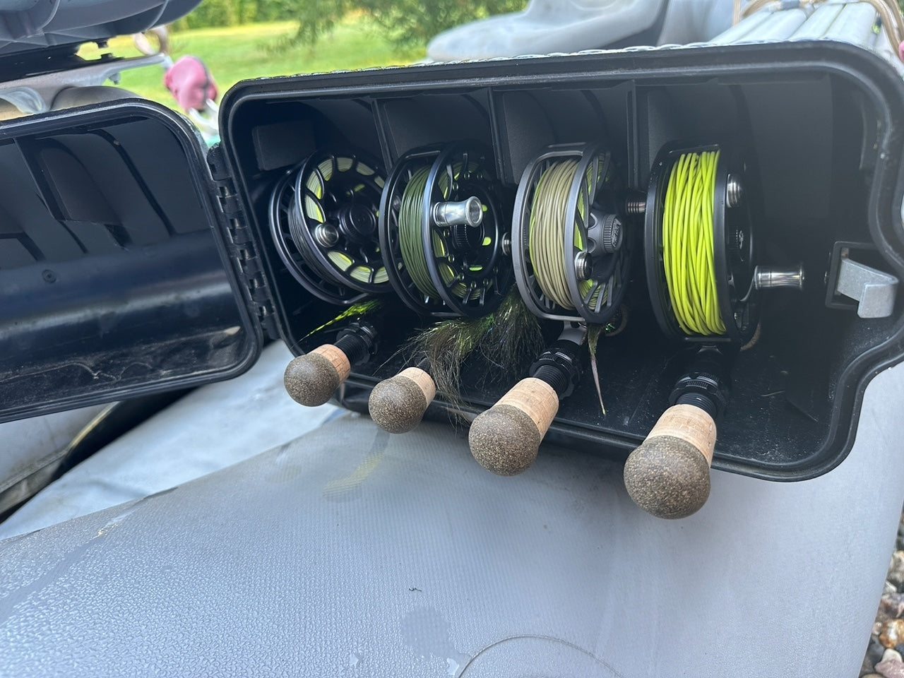 Carrying case with various colored fly lines, flies, and fly fishing rods.