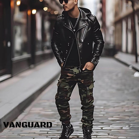 Man in a black leather jacket and camo cargo pants standing on a cobblestone street