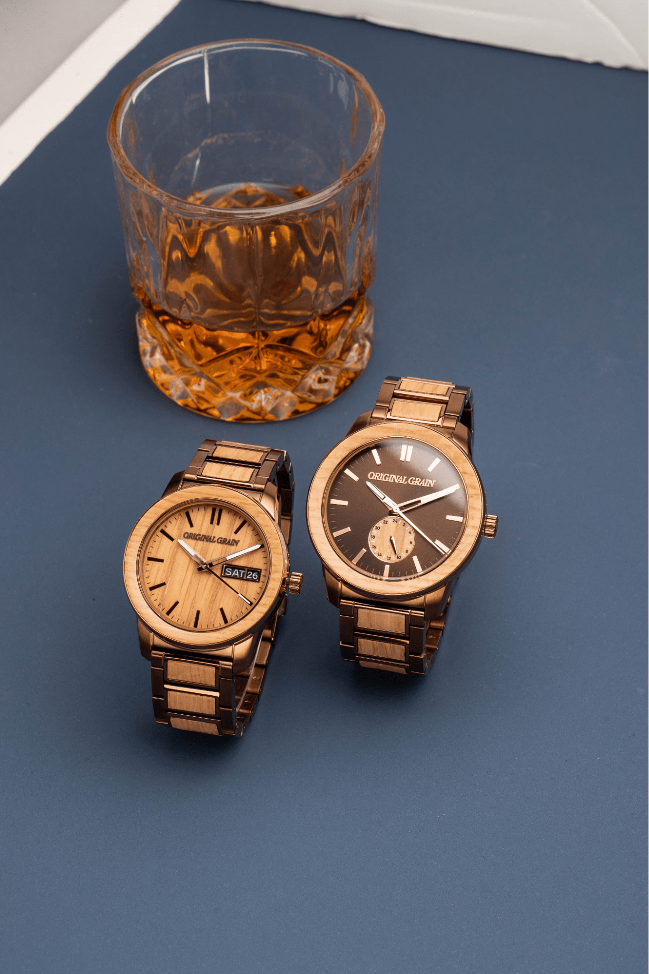 Image of two Original Grain watches next to a glass of Whiskey