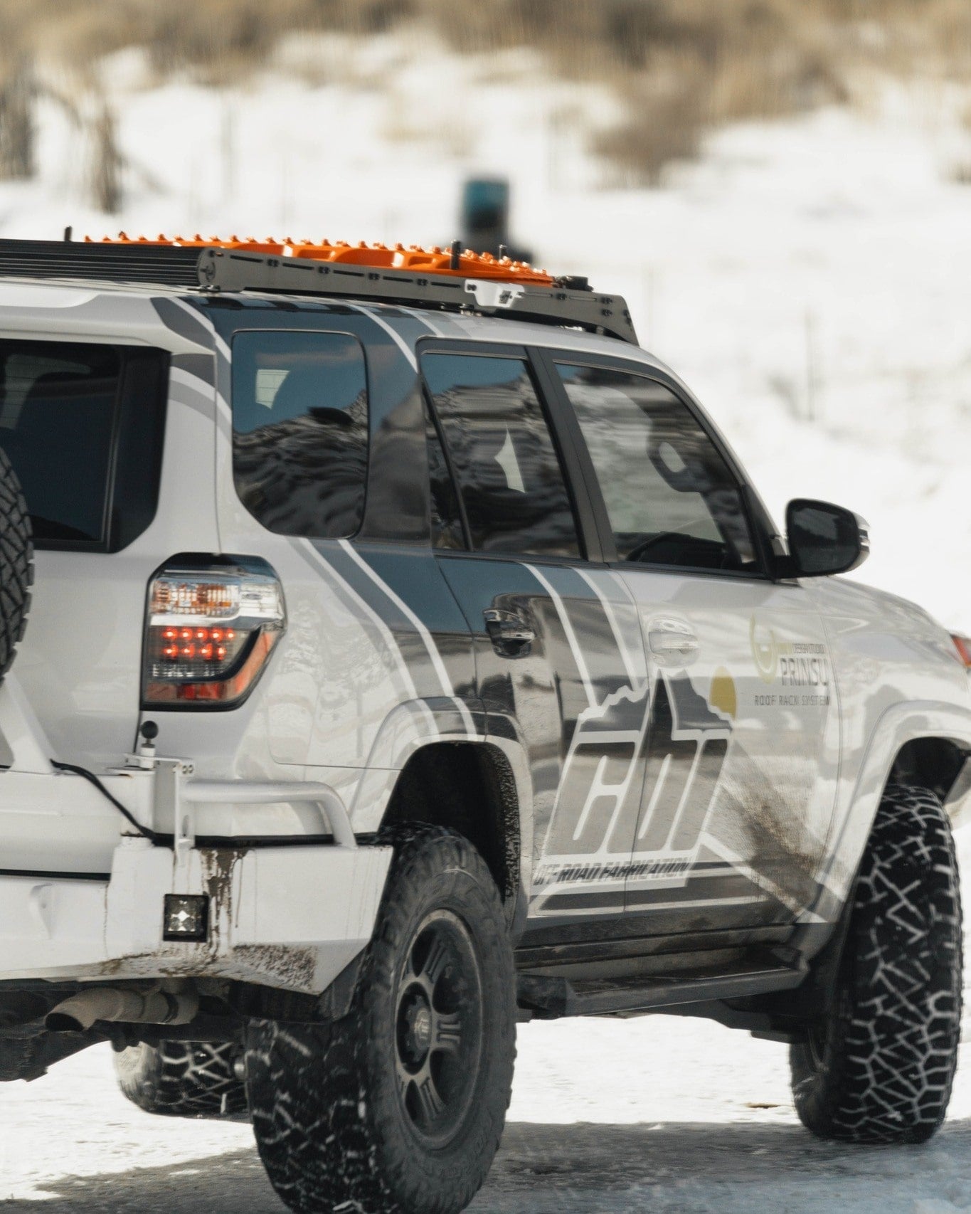 Prinsu Rack on top of a white 4Runner driving in the snow - Truck Brigade
