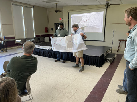Lucas holding up a map during a presentation at the DNR conference