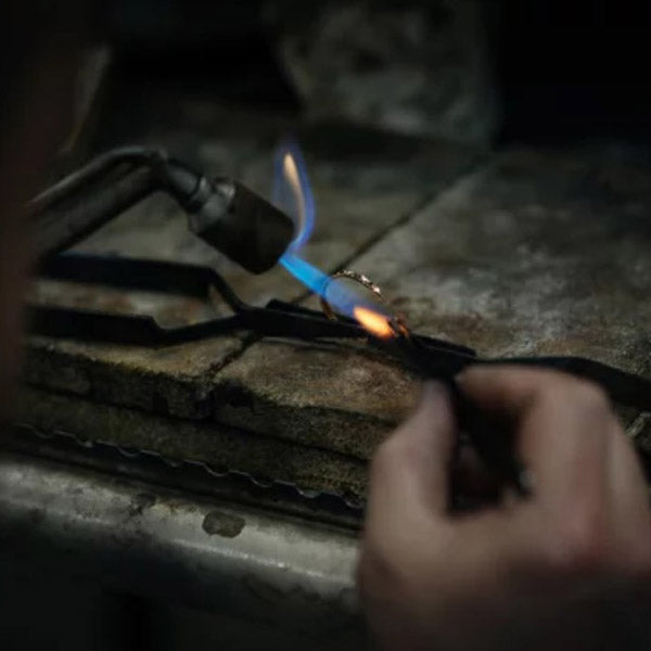 Jeweler is working by using a Gas spraying tool to hand make a ring that possesses a unique allure that sets it apart from mass-produced rings.