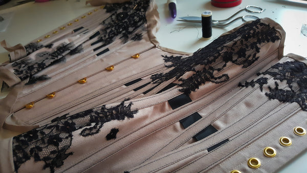 The corset being embellished with black lace.