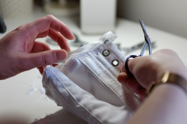 Hand sewing the binding of a corset