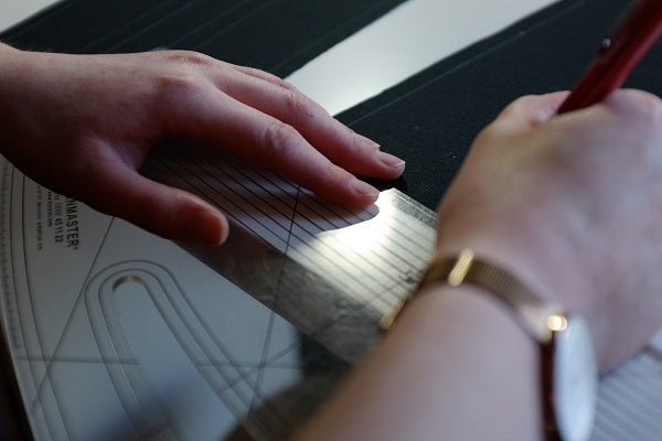 Close up of hands marking fabric