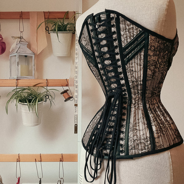 The back of a black lace overbust with black eyelets