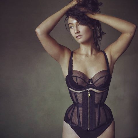 Model wears a black silk mesh corset with matching lingerie