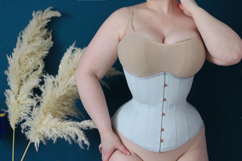 A grey waist training corset with rose gold busk