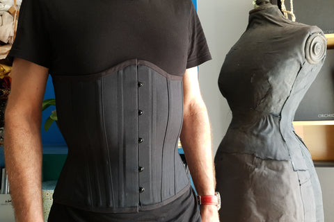 Male corset wearer in a black training corset