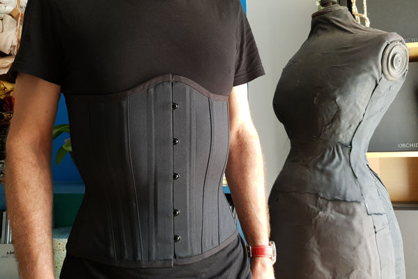 A male tightlacer wears a training corset