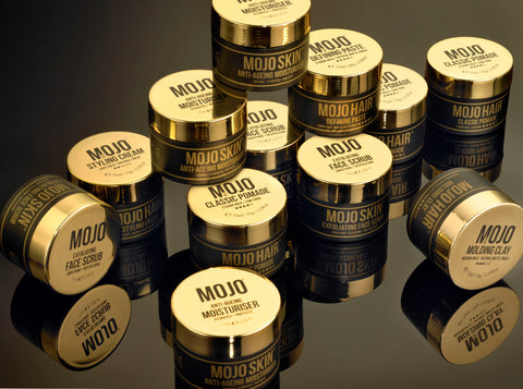 Stylish Product Photograph of the MOJO Skin & Haircare Range - which consists of four MOJO hairstyling products,Clay,Defining Paste,Classic Pomade and Styling Cream and two skincare products MOJO Anti -Ageing Moisturiser & MOJO Exfoliating Face Scrub) the MOJO Pots are stylish, premium gold and black pots which feature a retro twist design. All MOJO pots feature the Union Jack and instructions on how to use the products. We use a block colour of gold and black on all of our products so they stand out at the point of sale in store and look great in both the home, bathroom or office