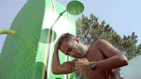 Man showering with a watch on a hot, sunny day