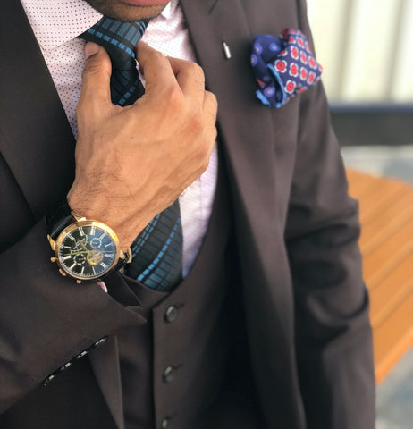 Man wearing a tuxedo and luxury watch in right hand for an occasion