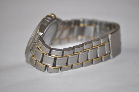 metal watch bracelet on a dim white background
