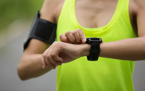 Young woman setting up her fitness watch before running