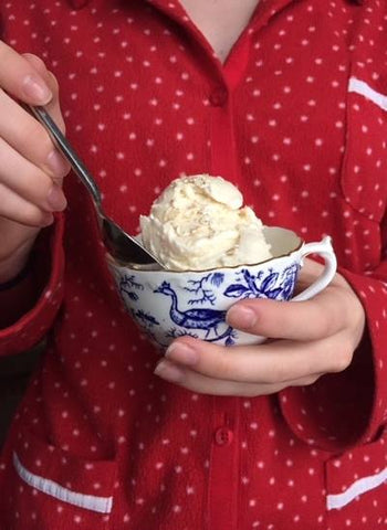 This is an image of someone in pajamas holding a dish of ice cream!