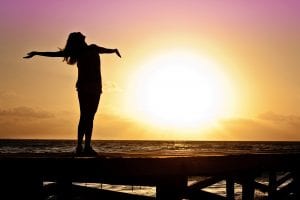 Femme qui profite du soleil sur un ponton au bord de la mer