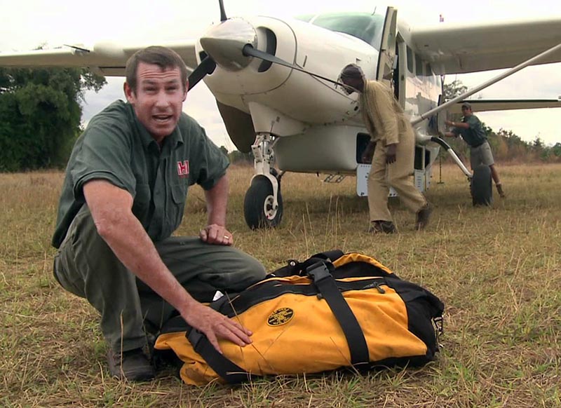 Ivan Carter and a Red Oxx Big Oxx Bag prep for a puddle jump chartered flight in Africa.