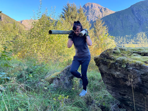 Merethe bærer gjerder i ulendt terreng. Foto Kjell Ivar Hansen