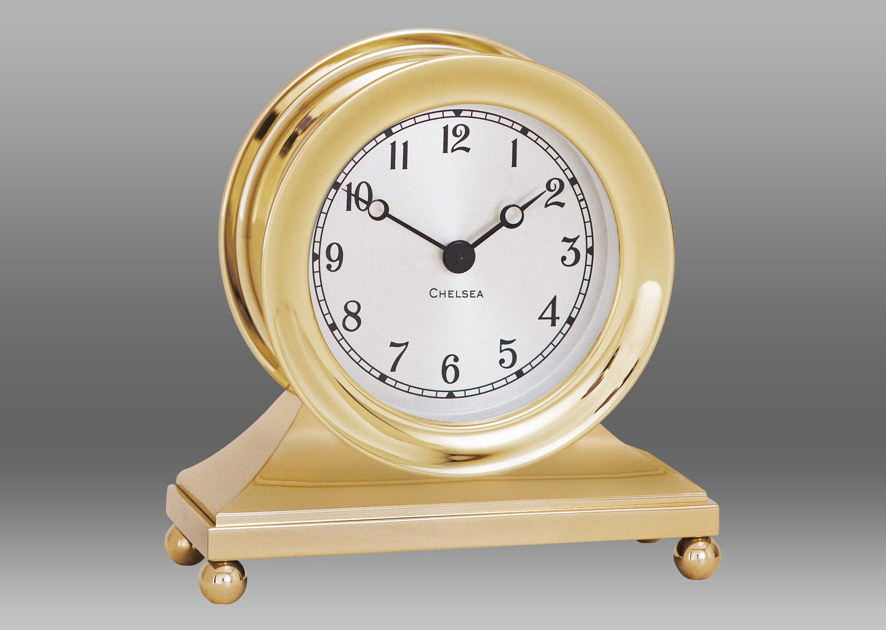 A gold clock with a white face Description automatically generated