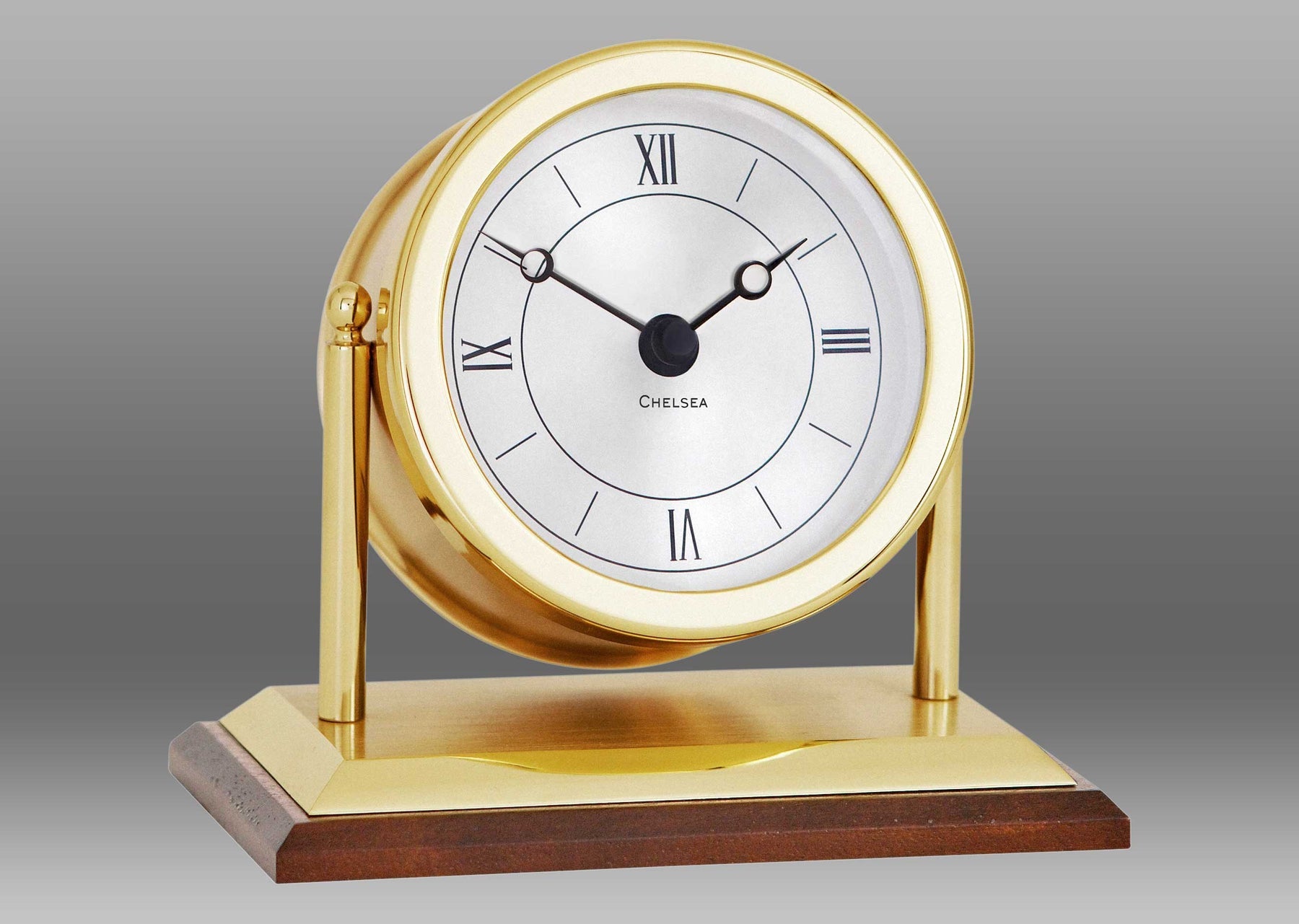 A gold clock with a white face Description automatically generated