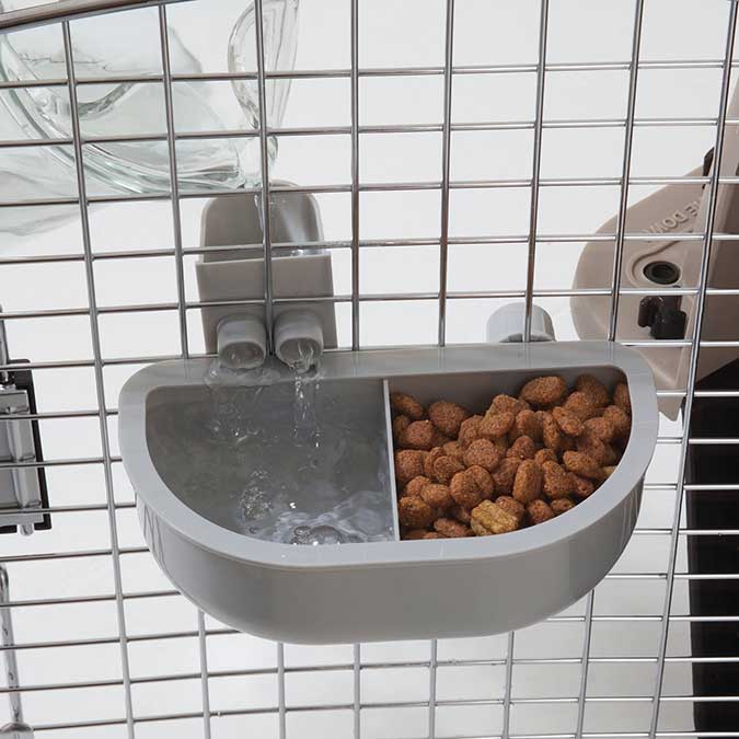 a kennel food and water dish attached to a kennel door
