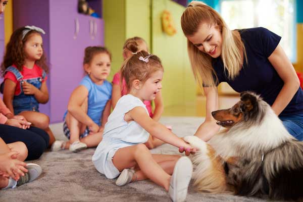 child petting a therapy dog in classroom