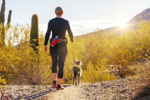 woman hiking with dog on a leash