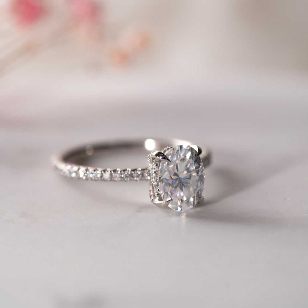 Shoulder set slim oval cut engagement ring in Platinum on a white background.