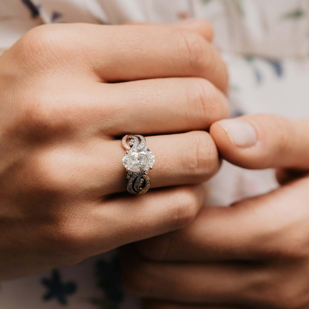 Statement accented large oval cut ring worn on models hand.