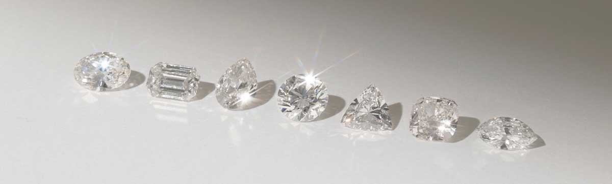 Row of different shaped diamonds on a white background