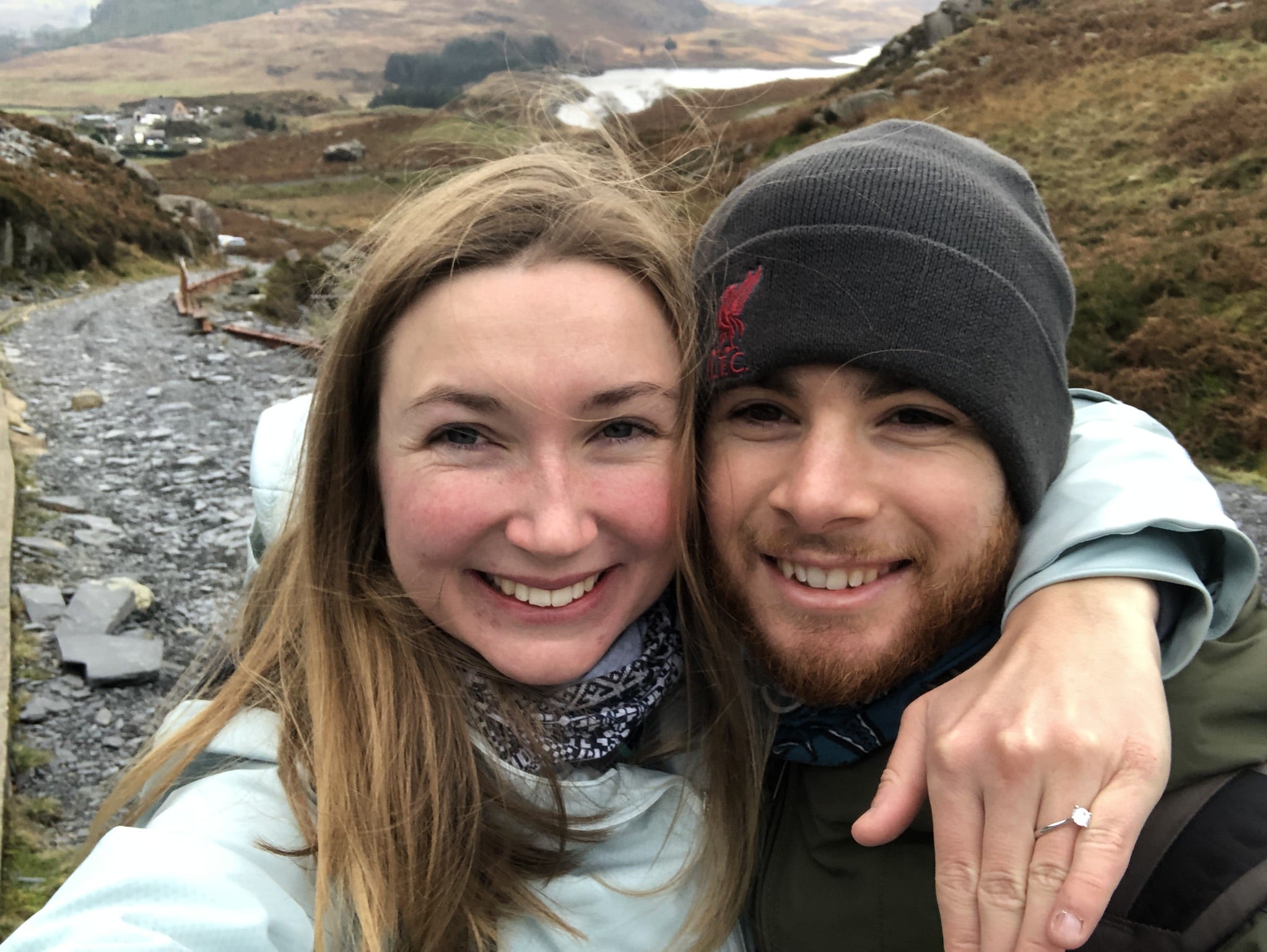 Finn and Annie showing off their engagement ring on a hike