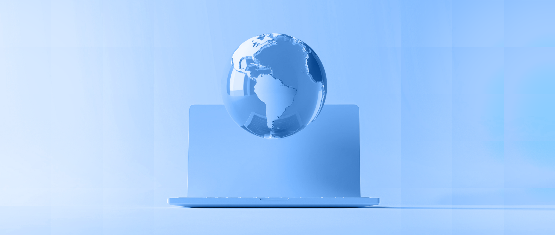 A transparent globe on a laptop in a monochrome blue setting, symbolizing global connectivity.