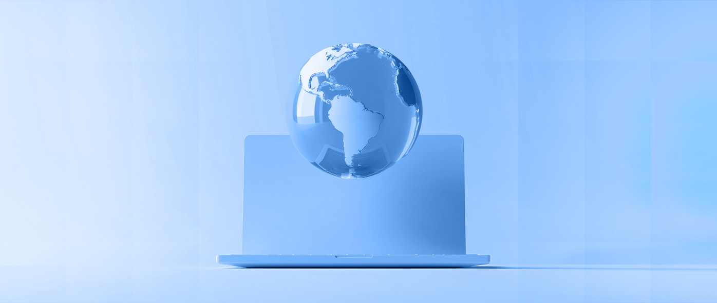 A transparent globe on a laptop in a monochrome blue setting, symbolizing global connectivity.