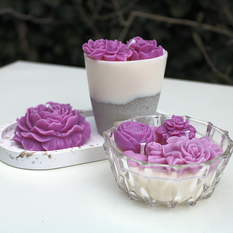 Sortiment an Kerzen mit lila Blüten
